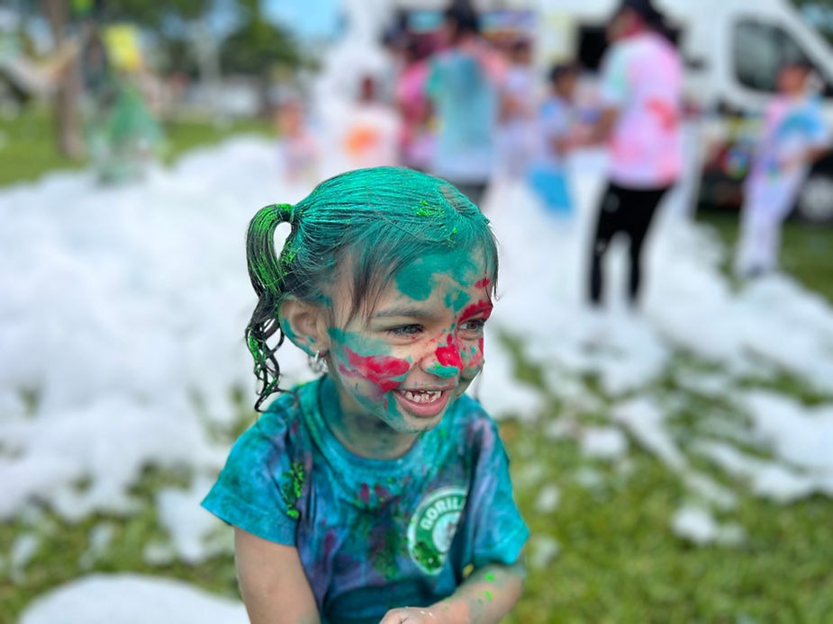 little girl filled with face paint and on her shirts in afoam party