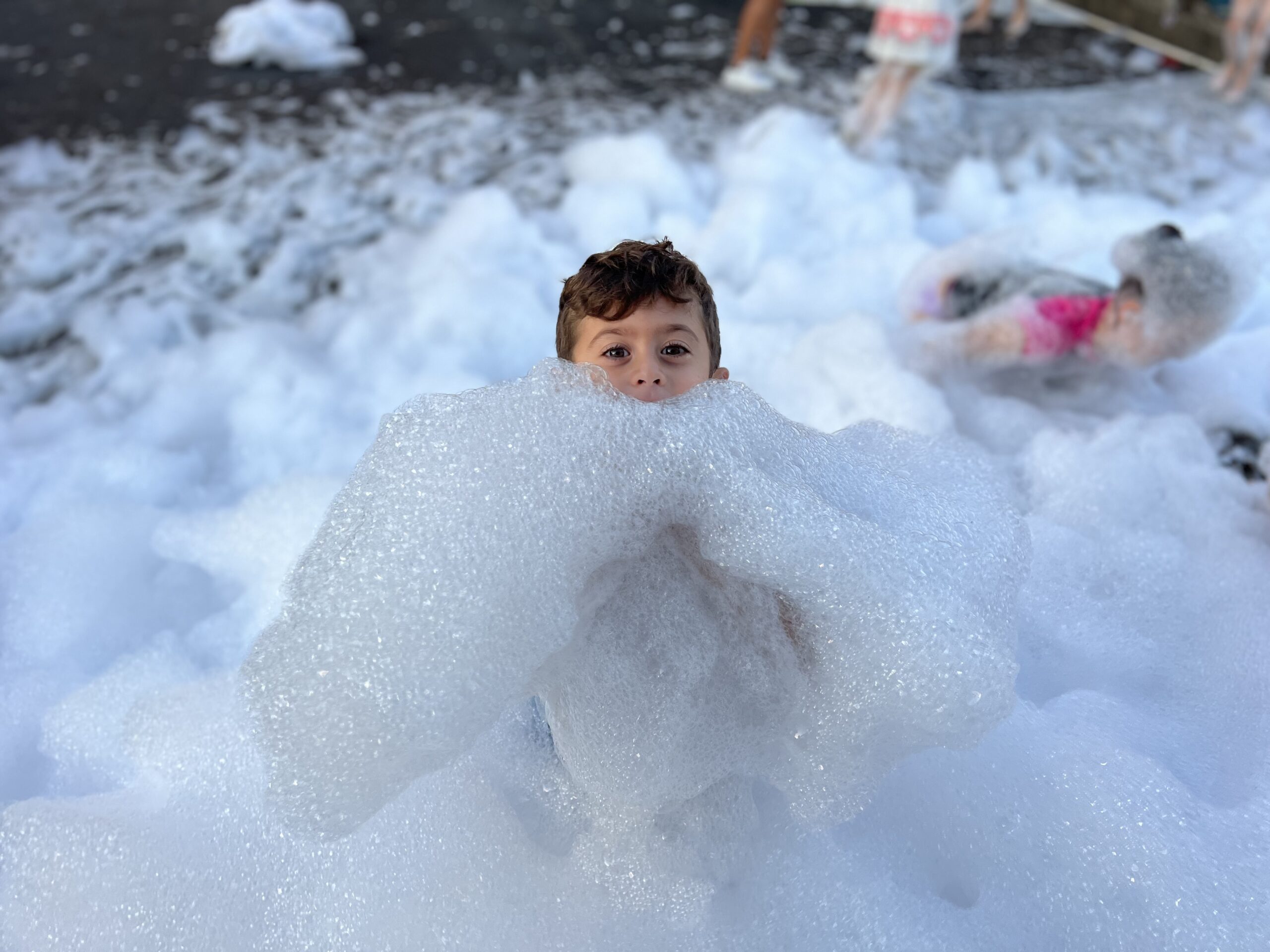 boy enjoying and swimming in foam 