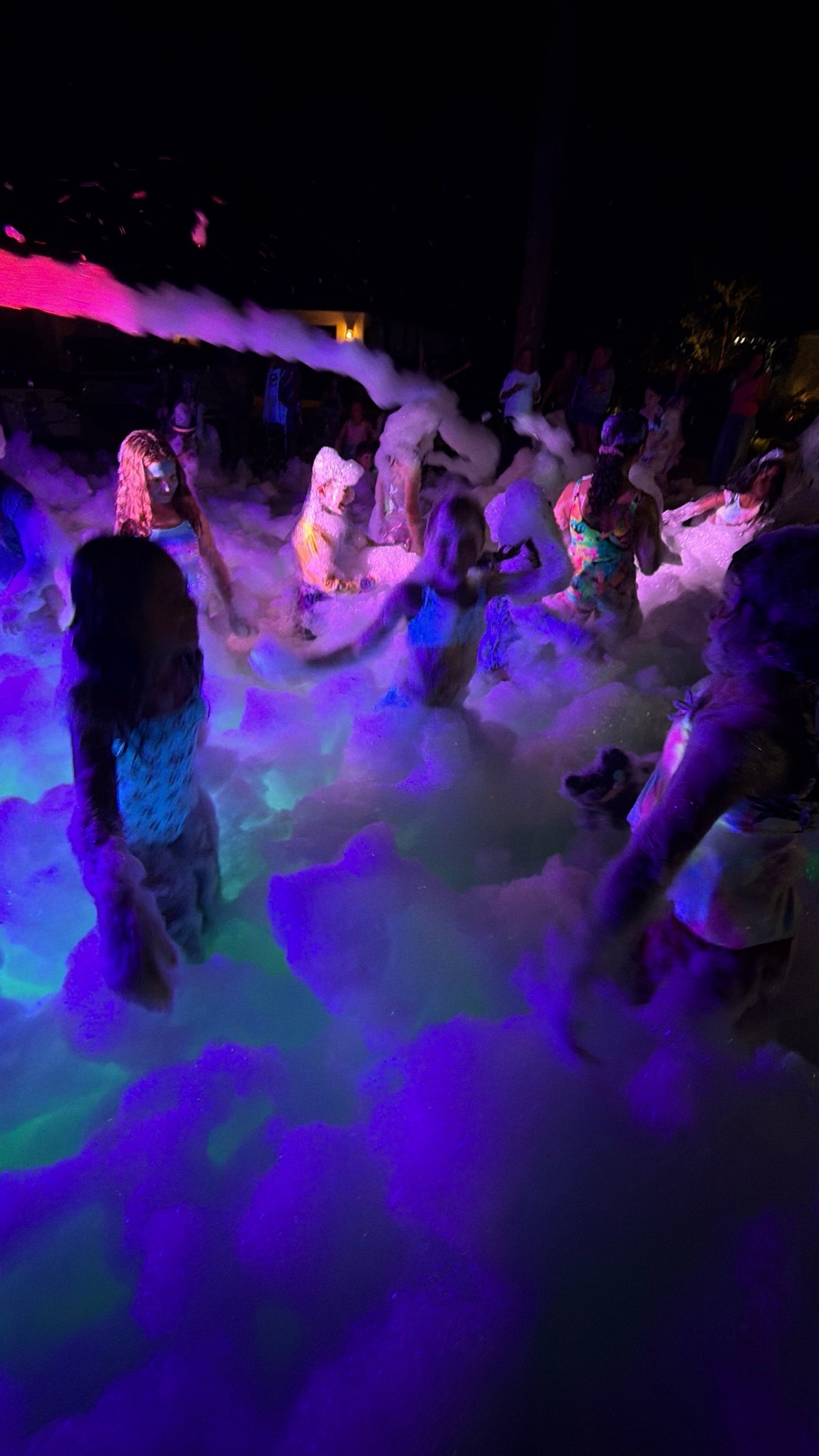 Kids playing in glowing foam at night at a Zombie Truck Foam Experience party