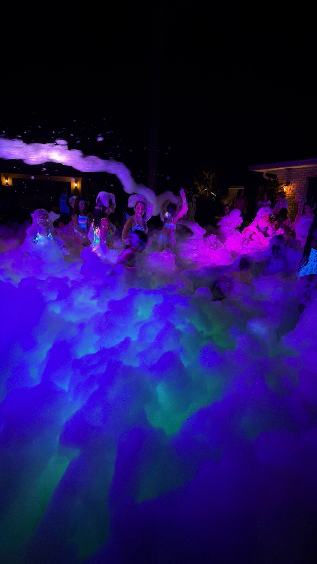 Wide view of a glowing foam party at night at a Zombie Truck Foam Experience party